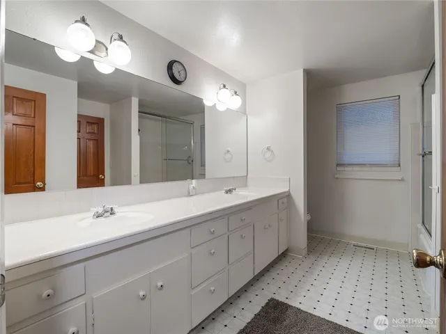 a bathroom with double vanity sink and a mirror
