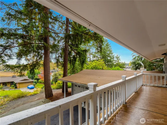 a view of a balcony and yard with wooden fence