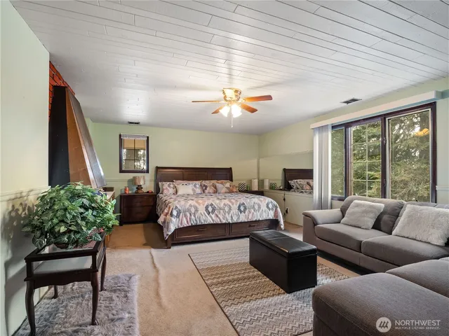 a bedroom with furniture and a large window