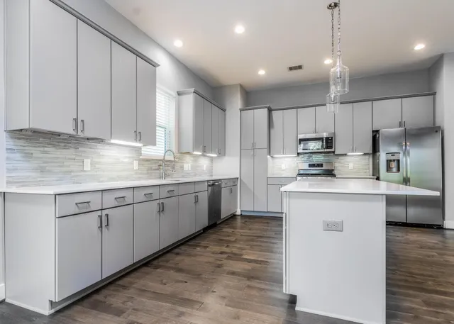 a kitchen with kitchen island granite countertop a sink window and refrigerator