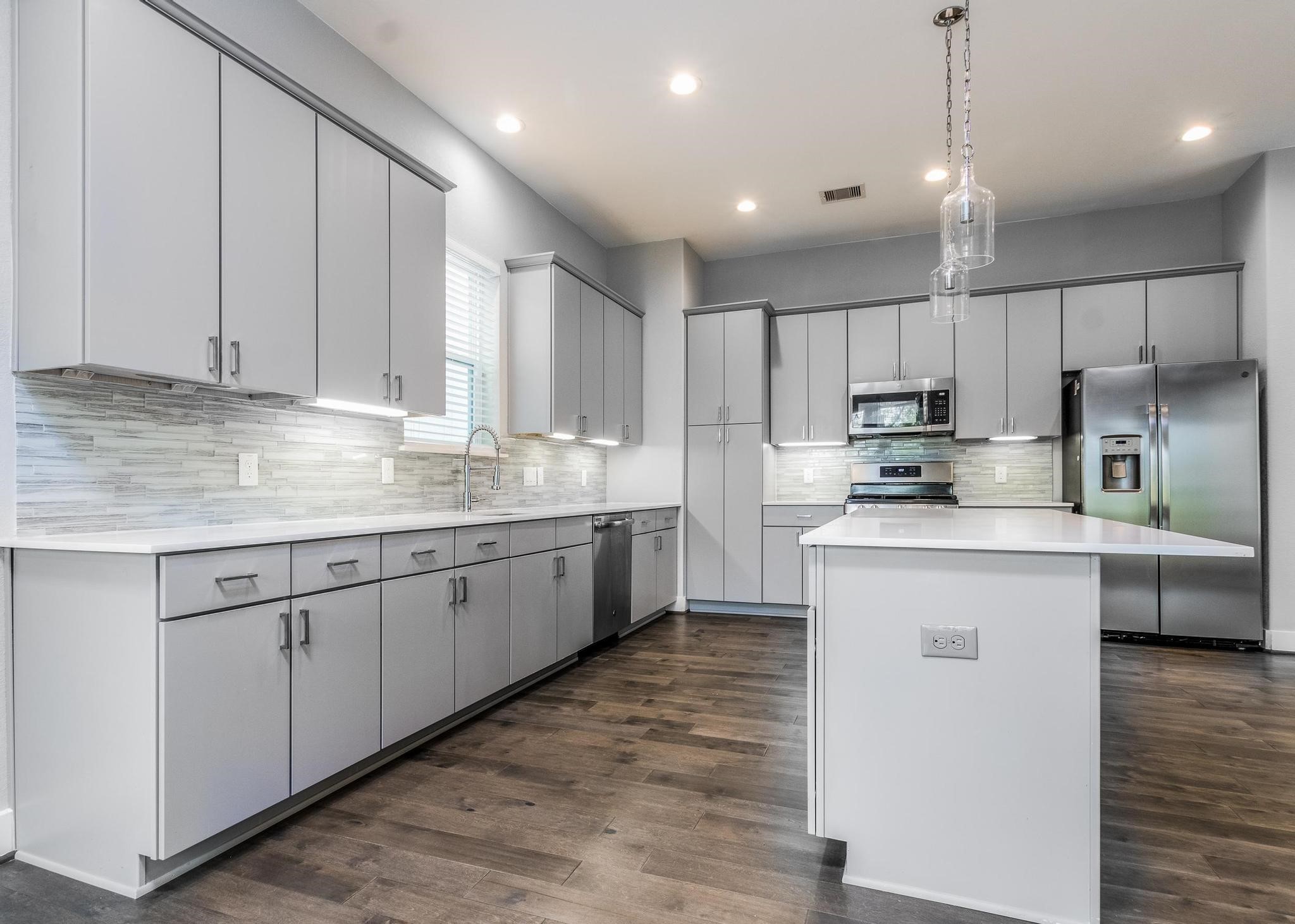 8409 Hempstead Road, Unit F Houston, TX 77008 - Photo 13 of 23 a kitchen with kitchen island granite countertop a sink window and refrigerator