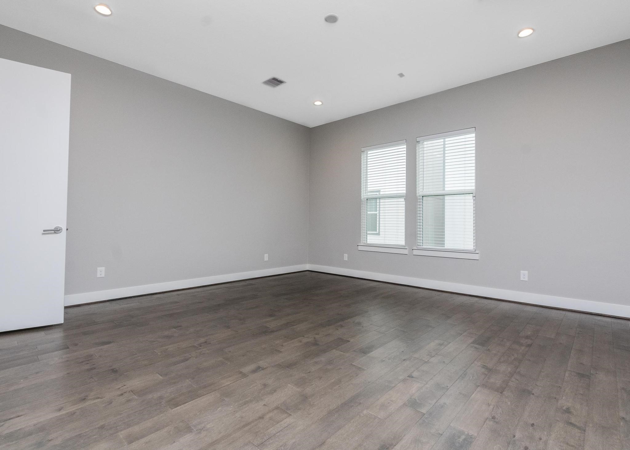 8409 Hempstead Road, Unit F Houston, TX 77008 - Photo 16 of 23 a view of an empty room with wooden floor and a window