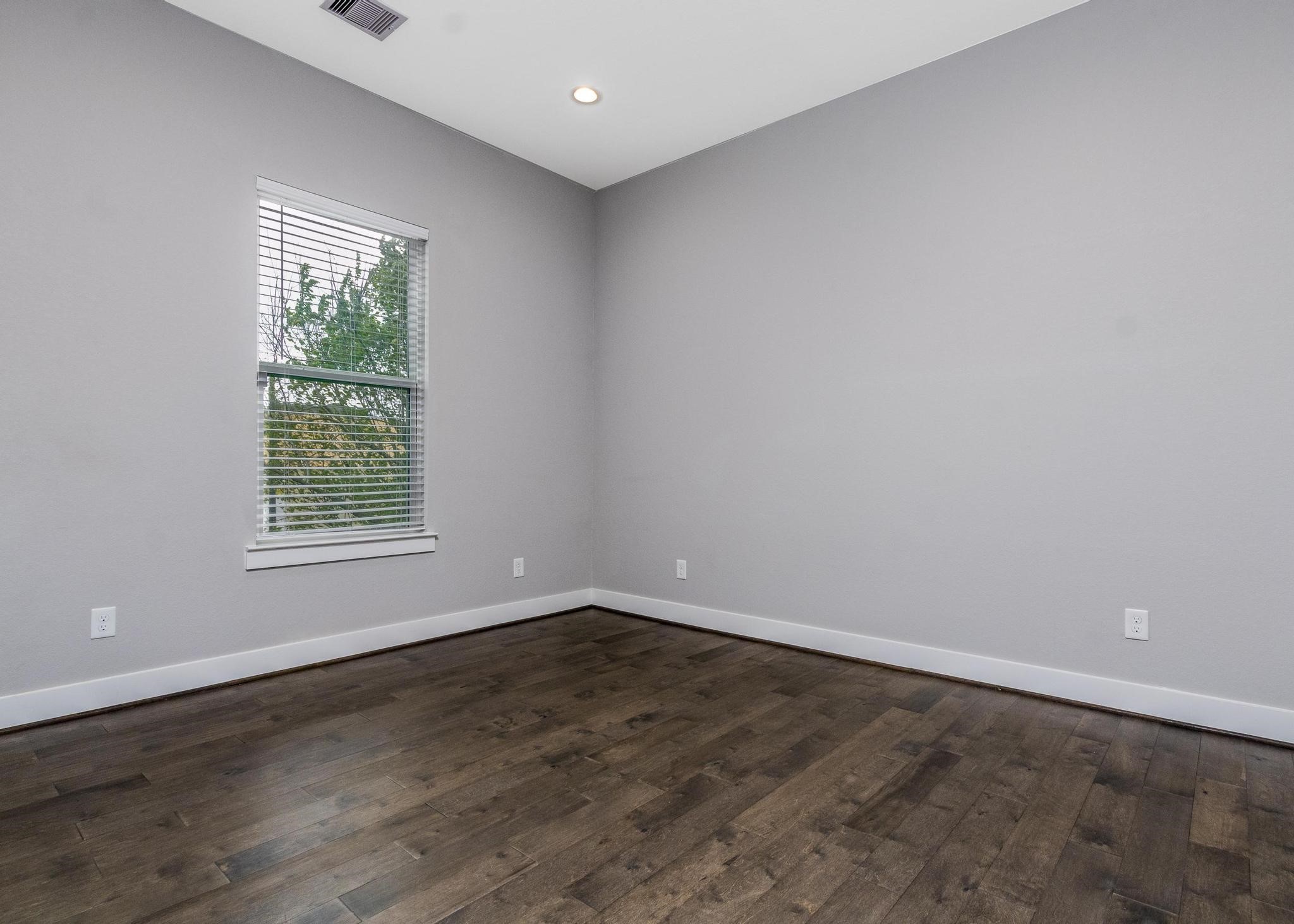8409 Hempstead Road, Unit F Houston, TX 77008 - Photo 20 of 23 an empty room with wooden floor and windows