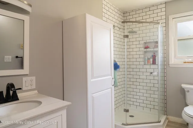 a bathroom with a sink a toilet and shower