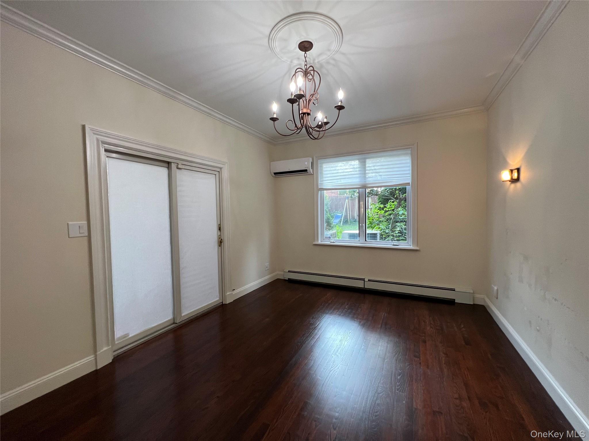 52-62 68th Street Queens, NY 11378 - Photo 9 of 15 an empty room with wooden floor chandelier and windows