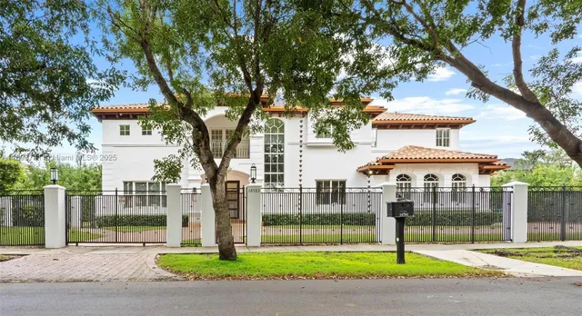 a view of a house with a big yard and large trees