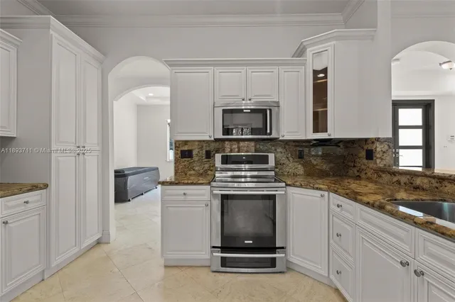 a kitchen with stainless steel appliances granite countertop a sink stove and microwave