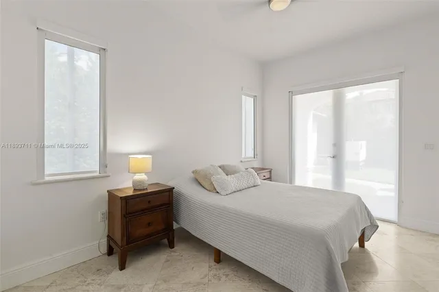 a bedroom with a bed and a large window