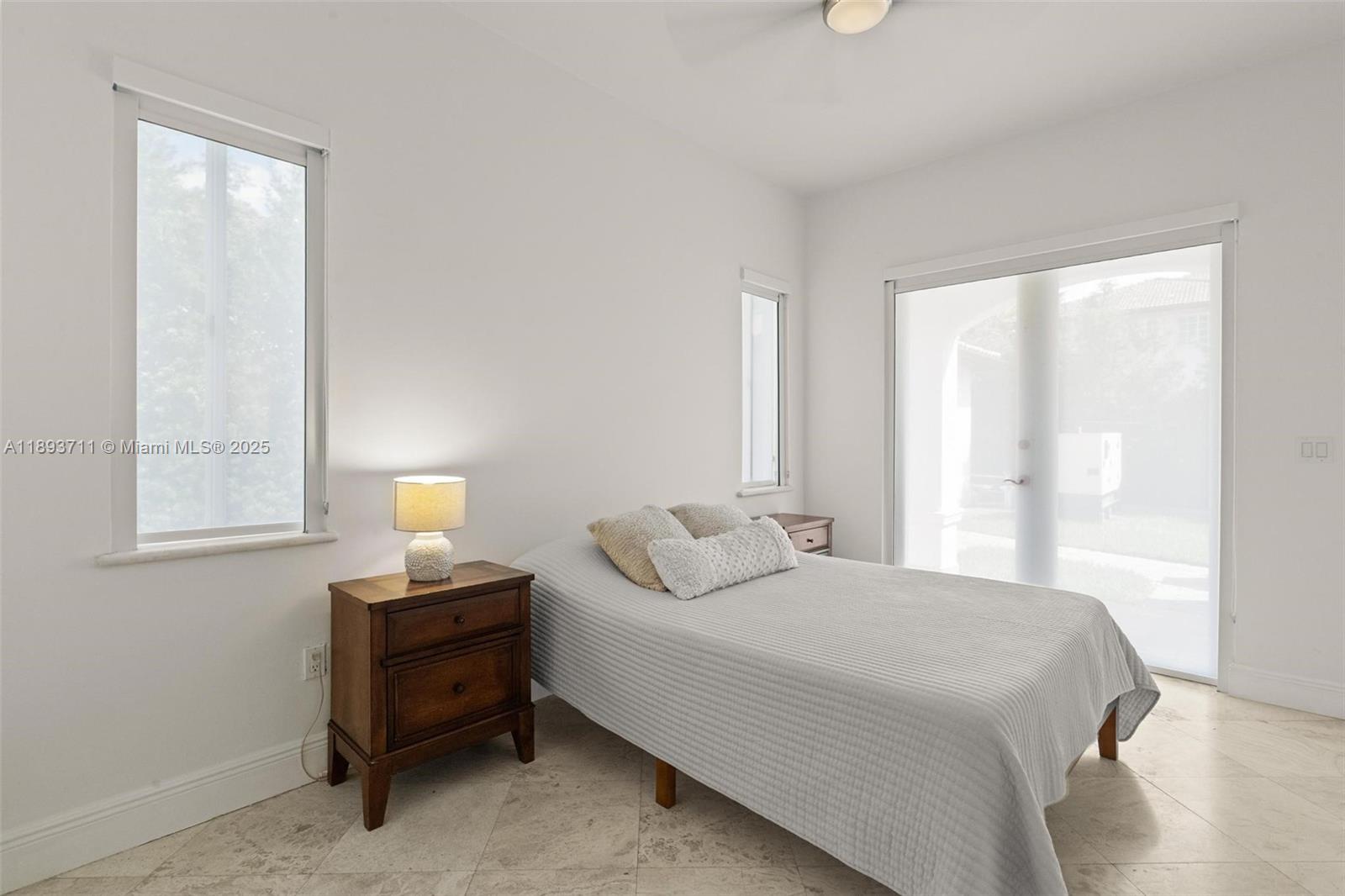 16763 Northwest 77th Path Miami Lakes, FL 33016 - Photo 30 of 53 a bedroom with a bed table and a window