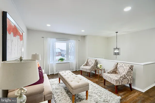 a living room with furniture and a painting on the wall