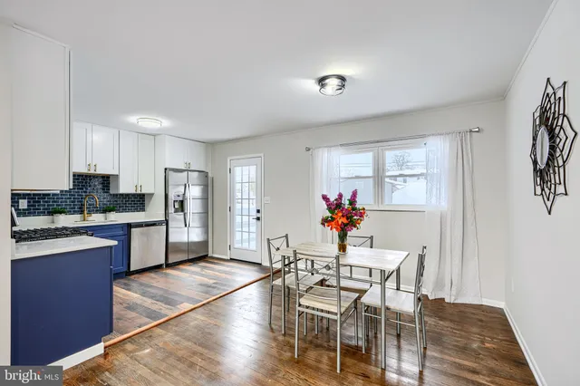 a kitchen with stainless steel appliances granite countertop a refrigerator sink dishwasher a stove and white countertops with wooden floor