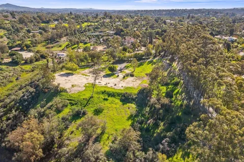 an aerial view of residential houses with outdoor space and trees