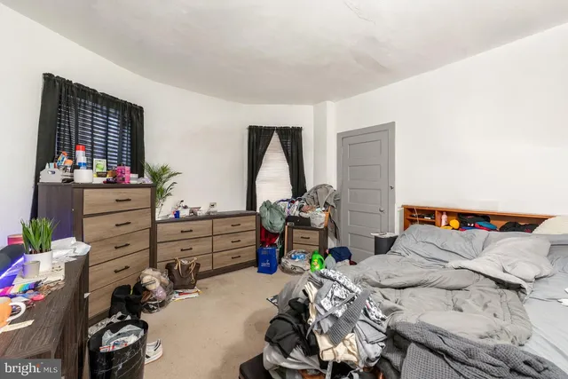 a bedroom with a bed and a dresser in it