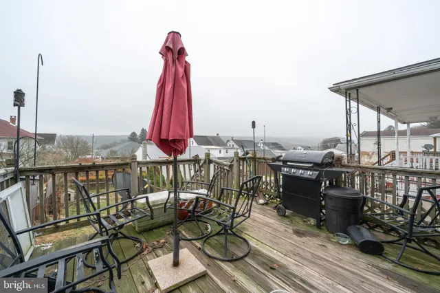 a view of a balcony with chairs and wooden floor