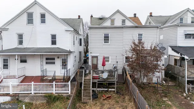 a view of a white house with large windows and a small yard