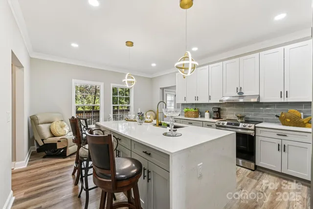 a kitchen with a stove a sink a dining table and chairs