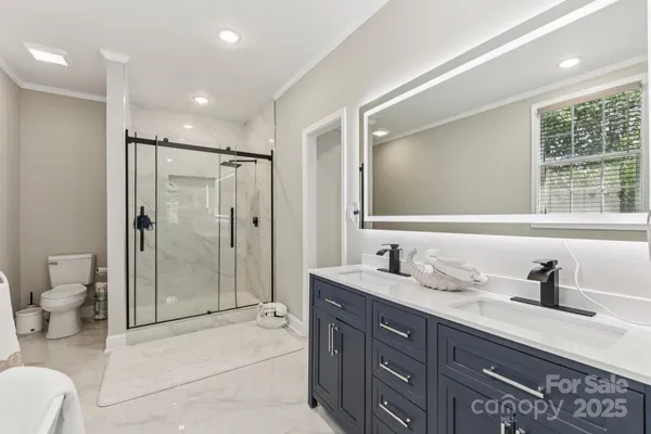 a bathroom with a double vanity sink toilet and shower