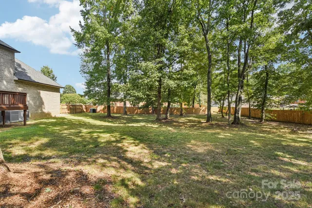 a view of a big house with a big yard and large trees