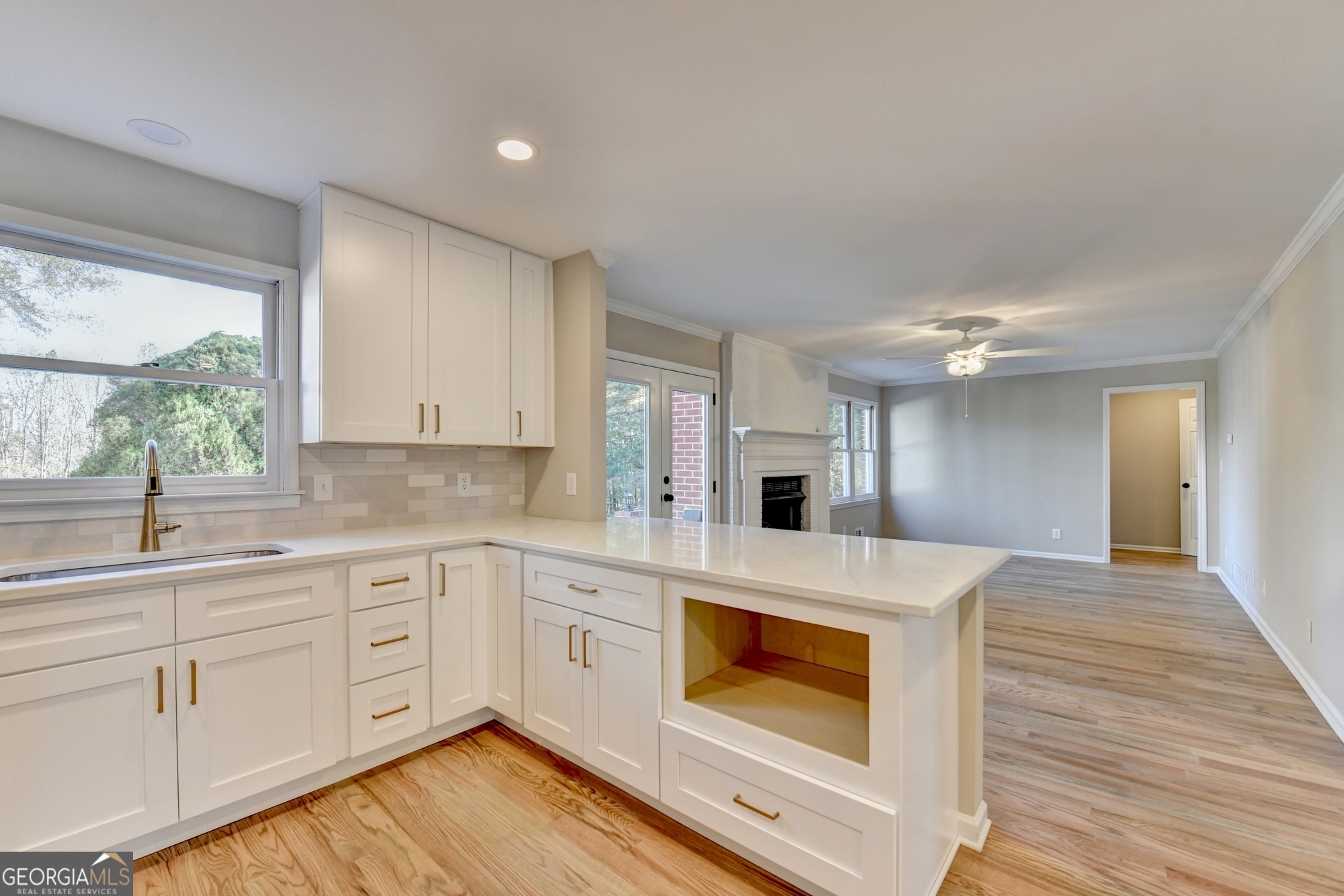 590 Manning Gin Road Monroe, GA 30656 - Photo 18 of 76 a kitchen with kitchen island a sink stainless steel appliances white cabinets and wooden floor