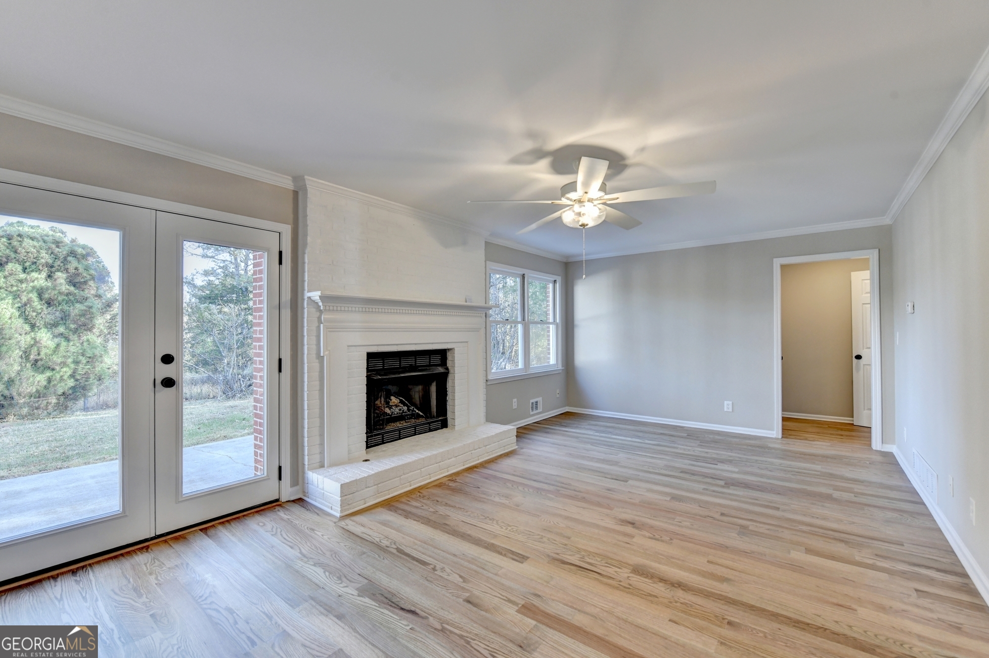 590 Manning Gin Road Monroe, GA 30656 - Photo 24 of 76 a view of an empty room with wooden floor fireplace and a window