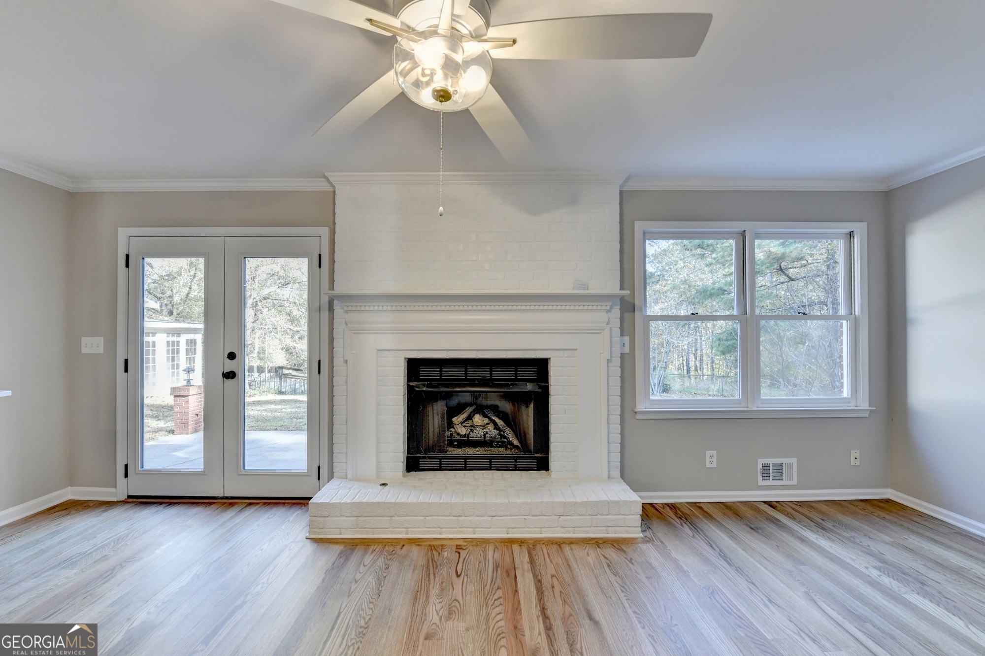 590 Manning Gin Road Monroe, GA 30656 - Photo 26 of 76 an empty room with wooden floor fireplace and windows