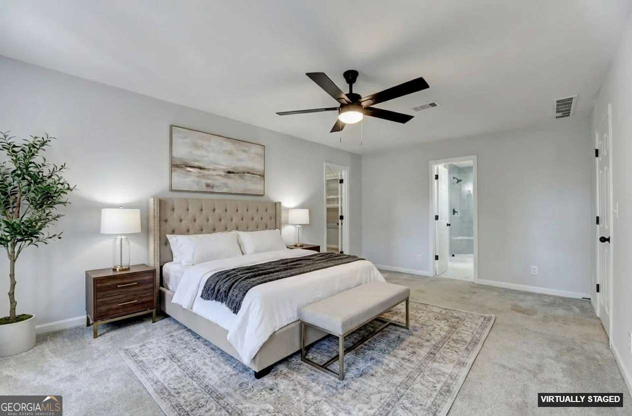 590 Manning Gin Road Monroe, GA 30656 - Photo 43 of 76 a spacious bedroom with a bed a plant and a chandelier