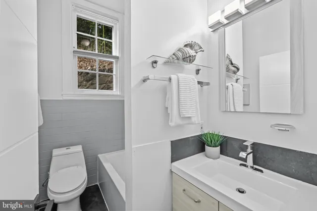 a bathroom with a toilet sink and mirror