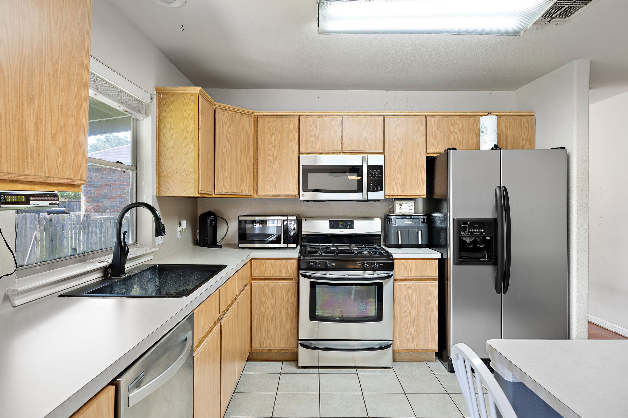 615 Runners Ridge Pflugerville, TX 78660 - Photo 11 of 32 a kitchen with a refrigerator sink and white cabinets