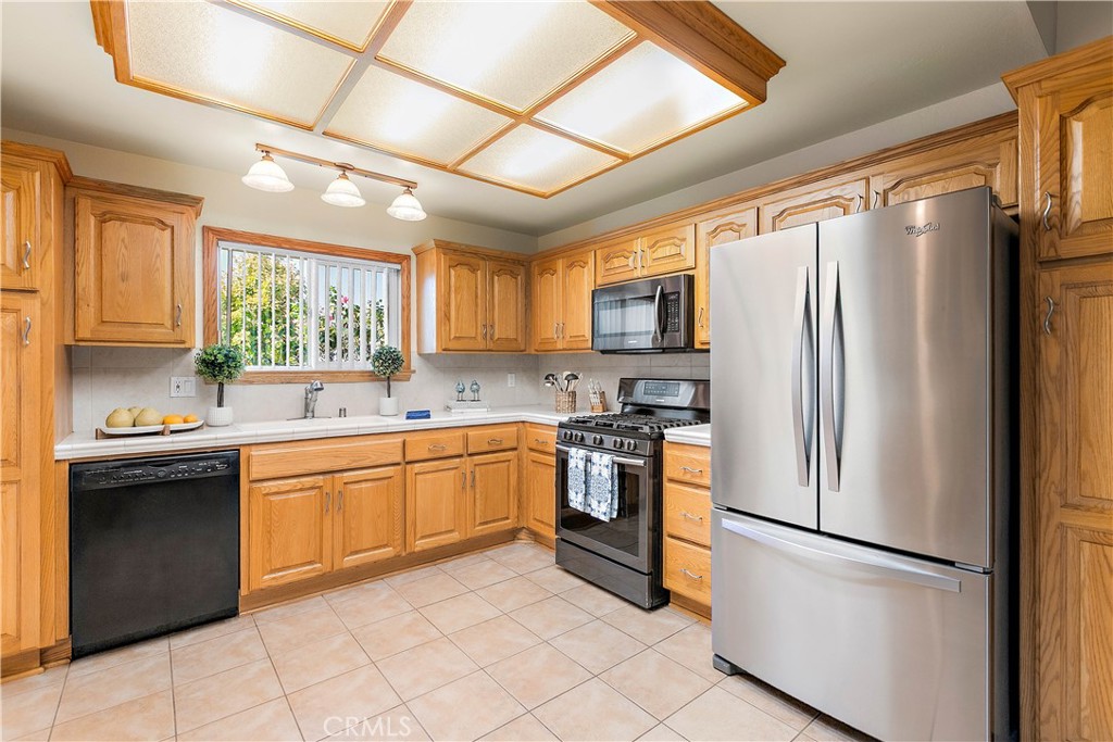 7241 Marine Avenue Rancho Cucamonga, CA 91701 - Photo 18 of 48 a kitchen with stainless steel appliances granite countertop a refrigerator a sink dishwasher a stove top oven a refrigerator and white cabinets
