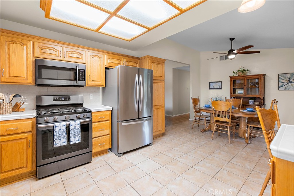 7241 Marine Avenue Rancho Cucamonga, CA 91701 - Photo 21 of 48 a kitchen with stainless steel appliances granite countertop a stove top oven a sink a dining table and chairs
