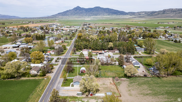365 South Center Street Fielding, UT 84311 - Photo 37 of 41 Aerial view of property and surrounding area featuring a mountain backdrop, nearby suburban area, and rural landscape