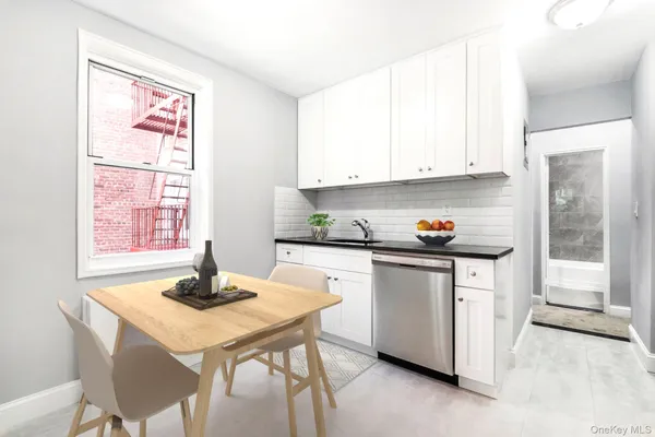a kitchen with stainless steel appliances kitchen island granite countertop a table chairs and a refrigerator