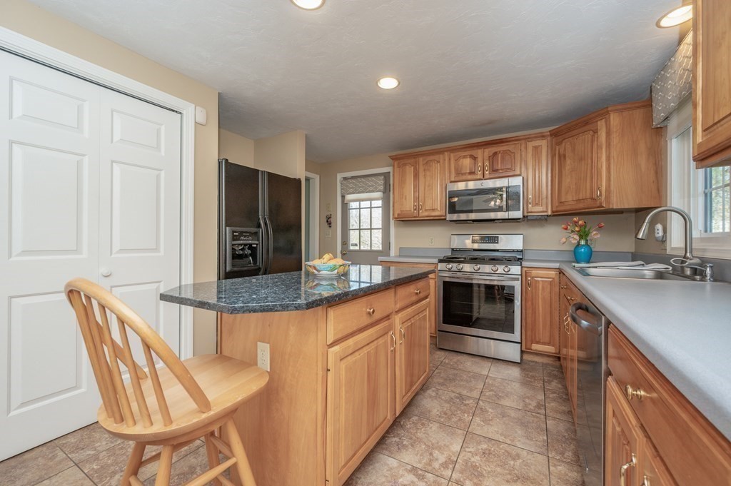 85 Elyse Road Mansfield, MA 02048 - Photo 12 of 30 a kitchen with stainless steel appliances granite countertop a stove top oven a sink dishwasher and a refrigerator