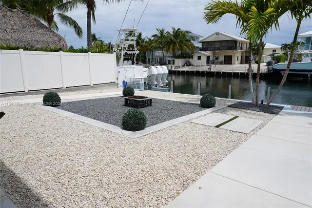 a backyard of a house with barbeque oven table and chairs