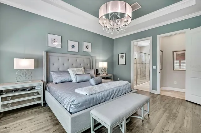 a bed room with a bed mirror and a chair