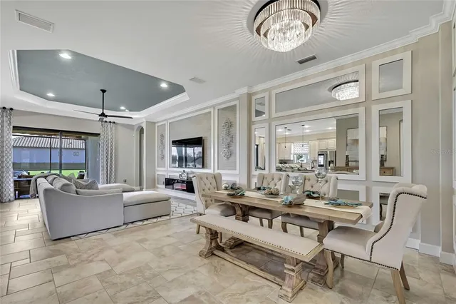 a kitchen with stainless steel appliances granite countertop a sink a stove a refrigerator cabinets and chairs