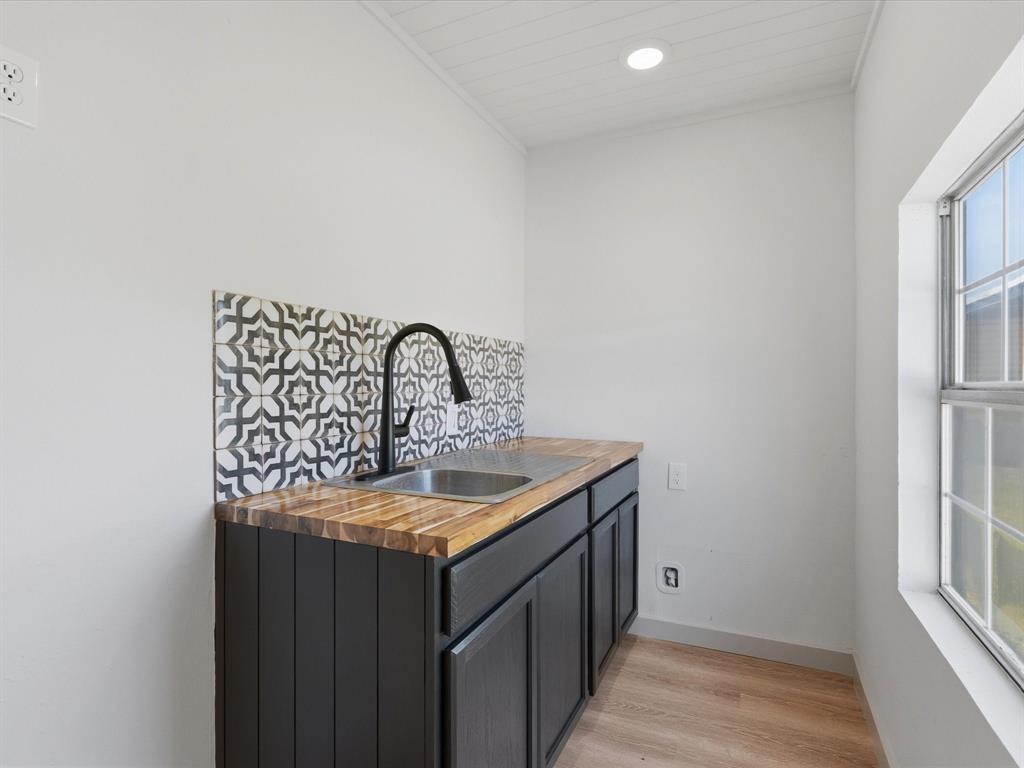 289 County Road 4655 Rhome, TX 76078 - Photo 23 of 34 ADU kitchen Utility sink with a matte black faucet, dark cabinetry, and a butcher block style countertop