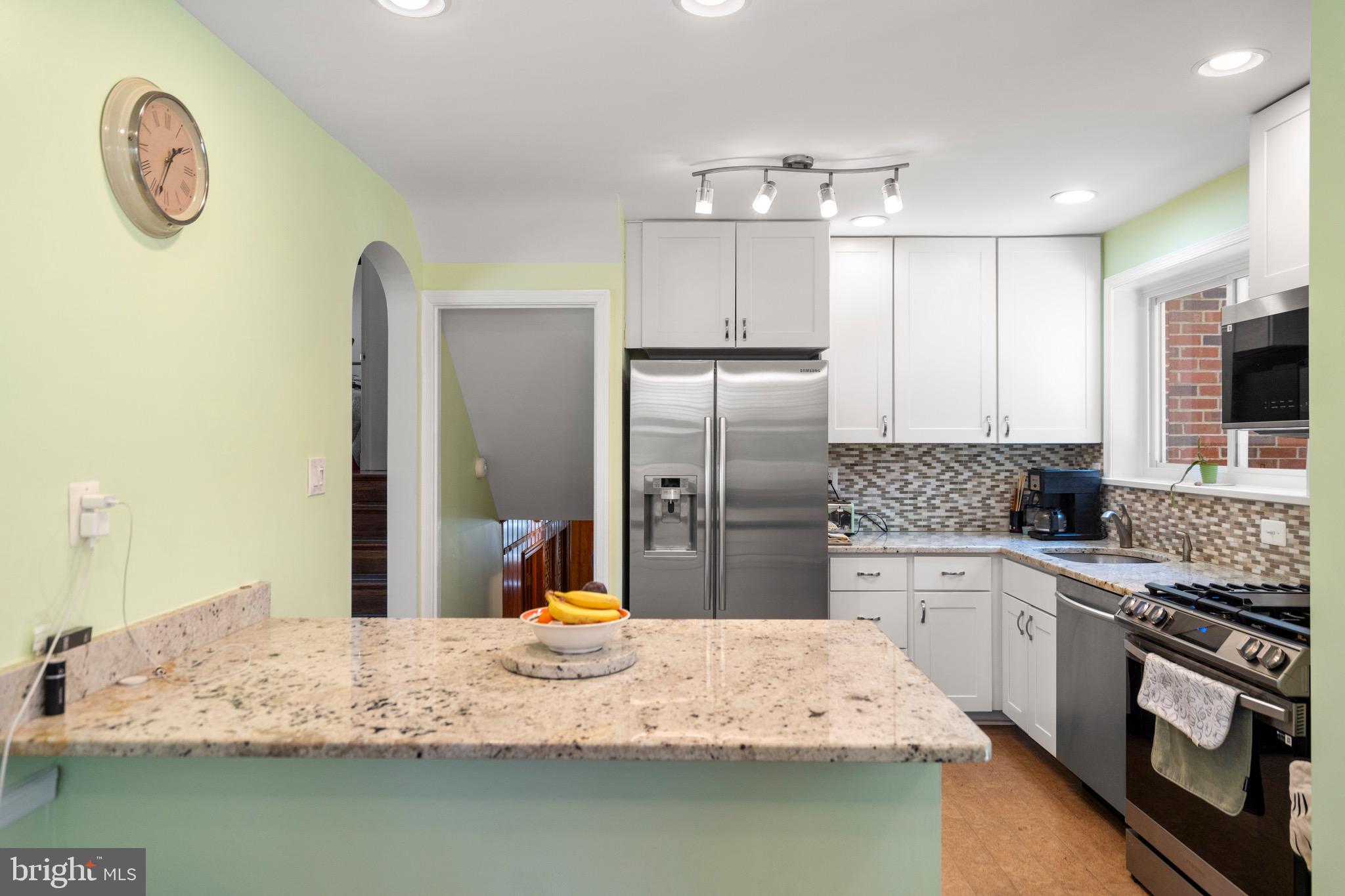 6110 Dorchester Street Springfield, VA 22150 - Photo 22 of 38 a kitchen with stainless steel appliances granite countertop a sink refrigerator stove and microwave