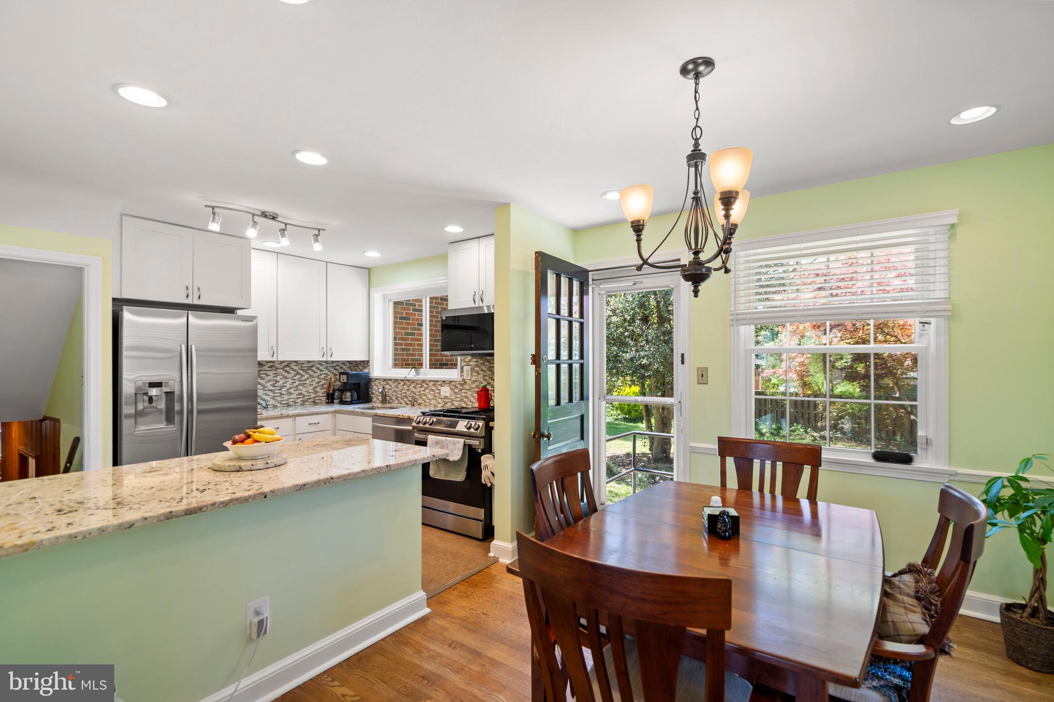 6110 Dorchester Street Springfield, VA 22150 - Photo 23 of 38 a kitchen with stainless steel appliances a dining table chairs stove refrigerator and cabinets