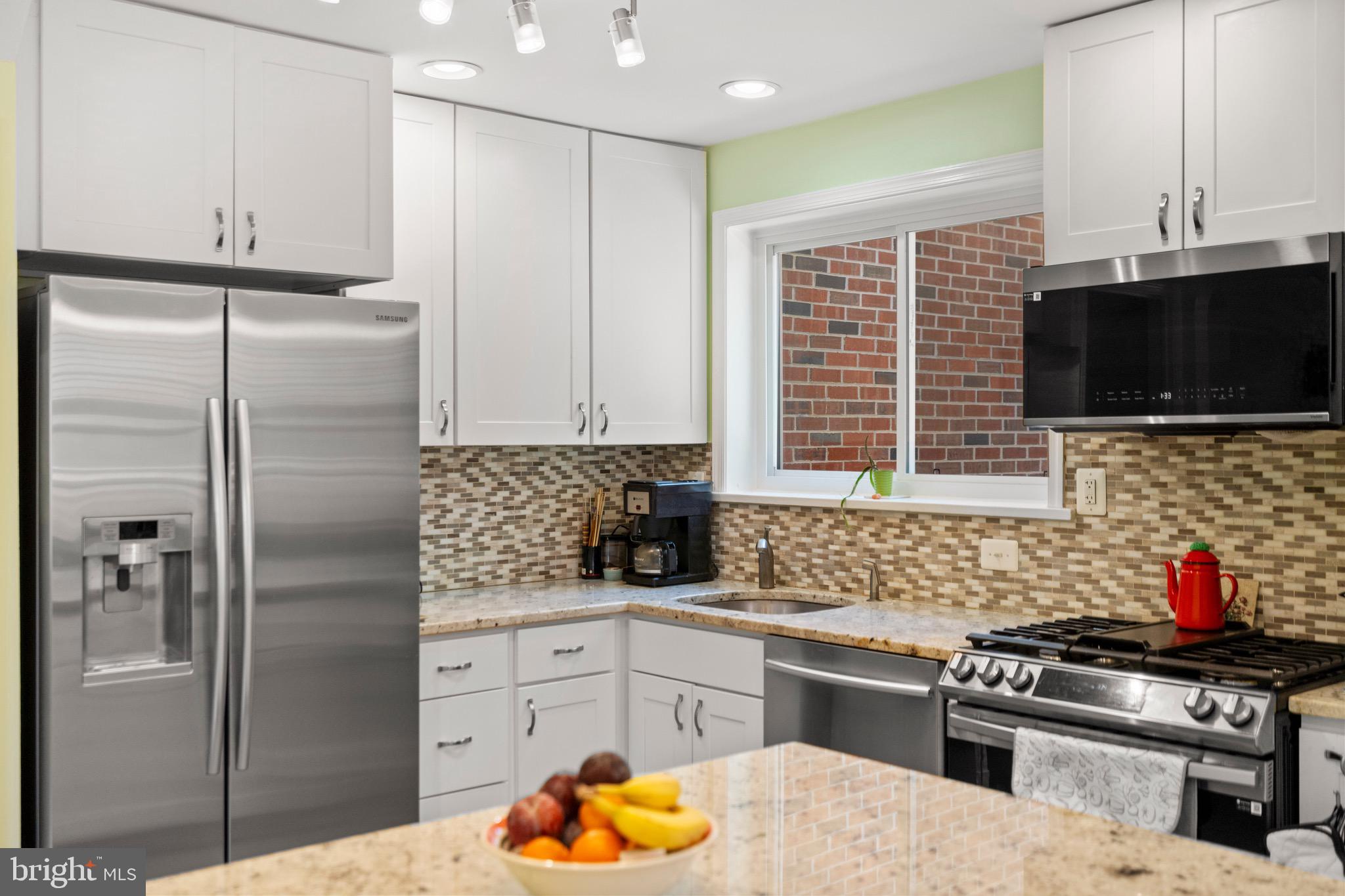 6110 Dorchester Street Springfield, VA 22150 - Photo 24 of 38 a kitchen with stainless steel appliances kitchen island granite countertop a refrigerator and a stove top oven