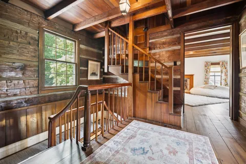 a living room with furniture a rug wooden floor and a fireplace