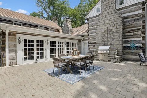 a patio with table and chairs and potted plants