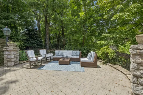 a view of a patio with couches table and chairs and potted plants