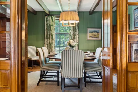 a dining room with furniture a rug and a large window