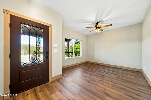 a view of an empty room with window and wooden floor