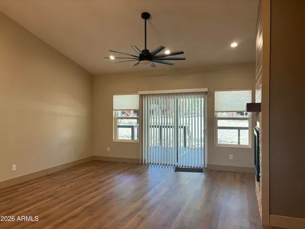 a view of a livingroom with a ceiling fan and wooden floor