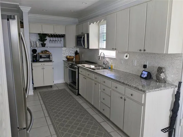 a kitchen with stainless steel appliances granite countertop a refrigerator sink and cabinets
