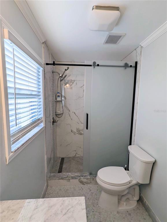 960 Gulf Boulevard, Unit 1 Indian Rocks Beach, FL 33785 - Photo 14 of 15 a white toilet sitting next to a bathroom sink and a shower