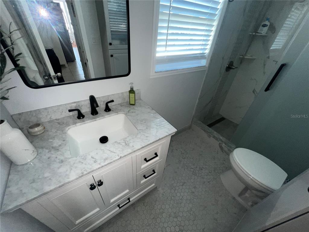960 Gulf Boulevard, Unit 1 Indian Rocks Beach, FL 33785 - Photo 7 of 15 a bathroom with a sink toilet and mirror