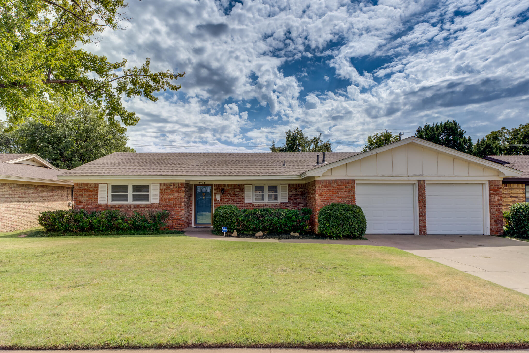 a front view of house with yard and trees in the background